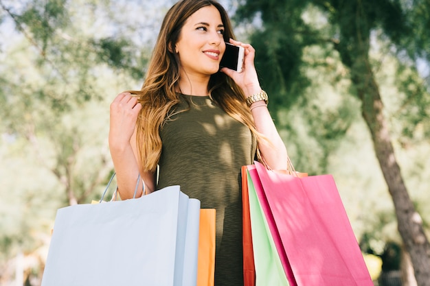 Smiley donna shoppinng e parlando al telefono