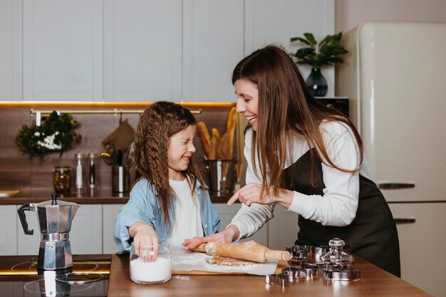 Smiley madre e figlia che cucinano in cucina a casa