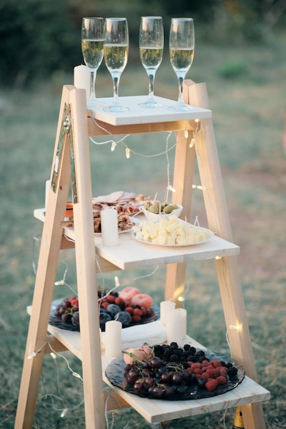 Snack ai frutti di bosco e champagne sulle scale decorate con lanterne per il banchetto di nozze
