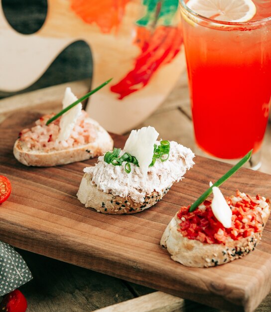 Snack sandwich sul tavolo con cocktail rosso