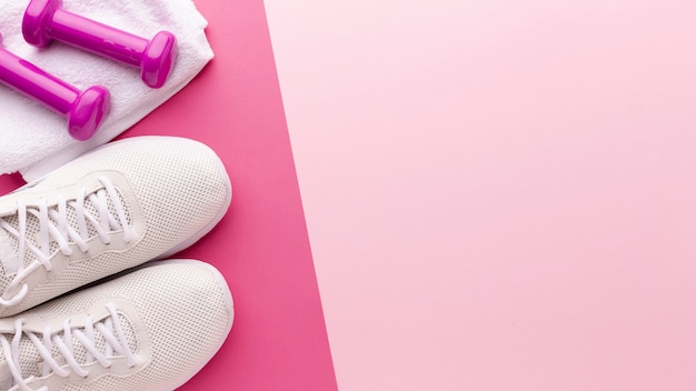 Sneakers bianche e pesi rosa con spazio di copia