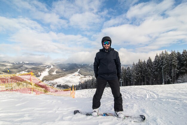 Snowboarder che scivola giù per la collina sulla pista di corsa sulla collina delle montagne