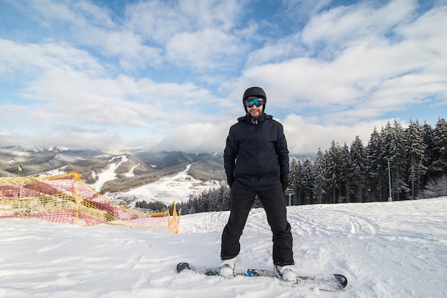 Snowboarder che scivola giù per la collina sulla pista di corsa sulla collina delle montagne