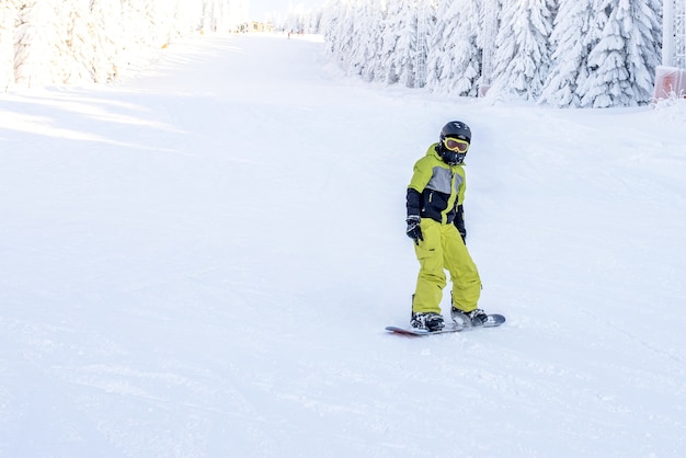 Snowboarder in movimento a cavallo giù per la collina nella località di montagna