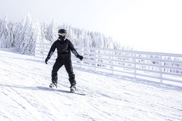 Snowboarder in movimento che scende dalla collina nella località di montagna