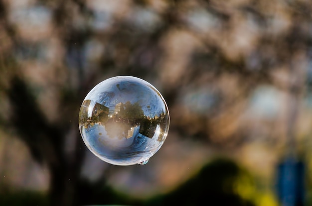 Soft focus di una bolla con la riflessione degli edifici della città e degli alberi su di esso