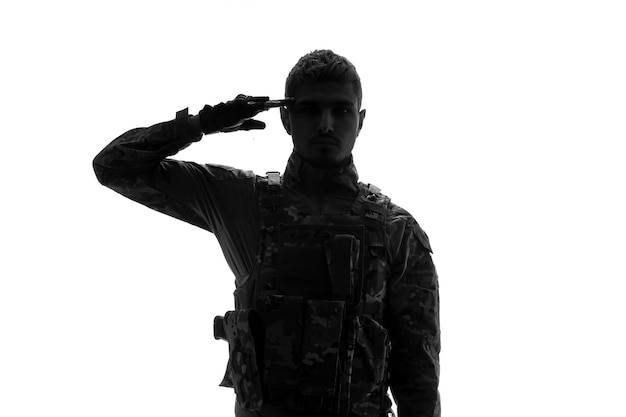 Soldato della siluetta del soldato serio bello forte duro dell'esercito in uniforme che tiene il dito contro la testa