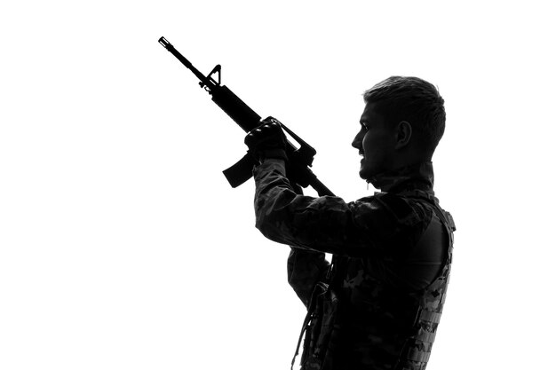 Soldato silhouette esercito duro bello serio forte soldato in uniforme che spara in aria