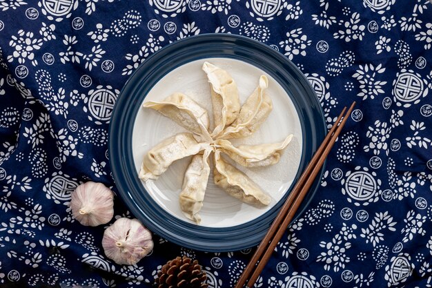 Somma fioca in un piatto bianco con aglio su un fondo blu floreale