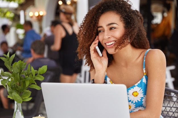 Sono contenta che la libera professionista si concentri sul lavoro a distanza, parla con il collega tramite smartphone, trascorre le pause di lavoro in un ristorante accogliente.