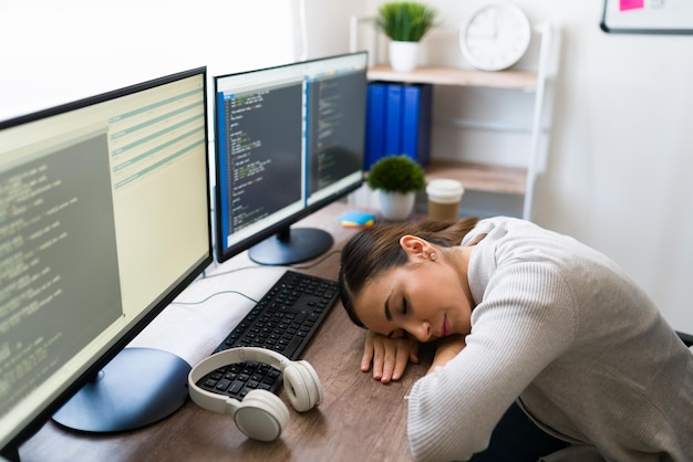 Sono così stanco. Donna assonnata che dorme sopra la sua scrivania durante la mattina. Programmatore freelance che si addormenta mentre lavora