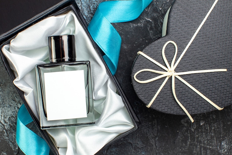 Foto gratuito sopra la vista del nastro blu sul profumo dell'uomo in una confezione regalo e una bella confezione regalo al buio