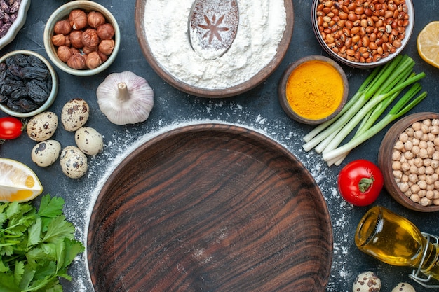 Sopra la vista del pasto cucinato con uova verdi fasci limone aglio limone e vaso marrone vuoto su blu