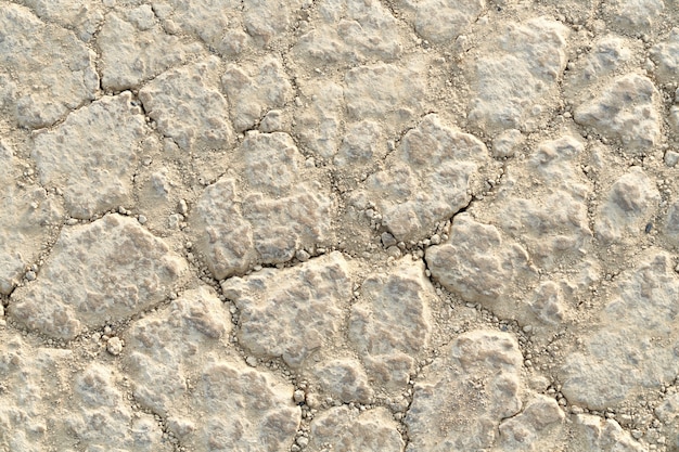 Sopra la vista del terreno bianco secco con piccoli sassi. Concetto di superficie della struttura della pietra.