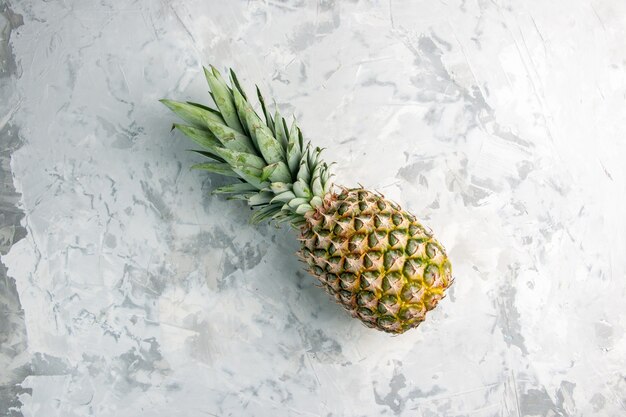 Sopra la vista dell'intero ananas dorato fresco sulla superficie di marmo