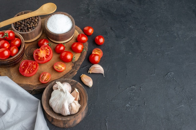 Sopra la vista di pomodori freschi e spezie su tavola di legno Asciugamani bianchi su superficie nera