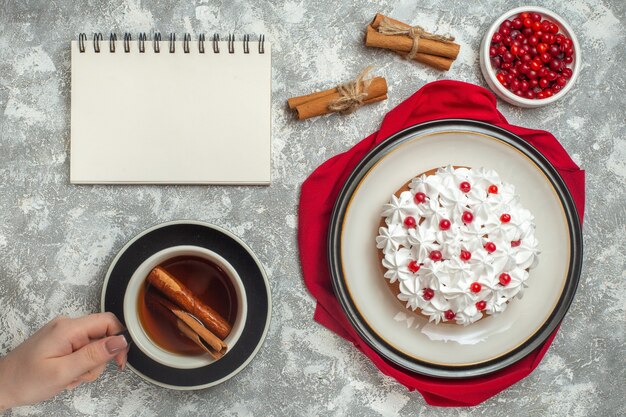 Sopra la vista di una deliziosa torta cremosa decorata con frutta su un panno rosso