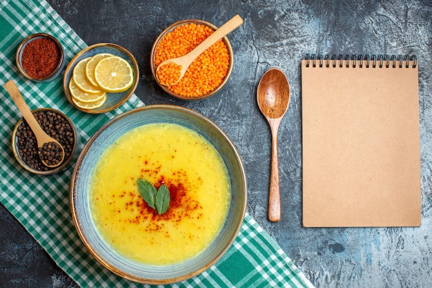 Sopra vista di una gustosa zuppa servita con menta e pepe su un panno spogliato verde