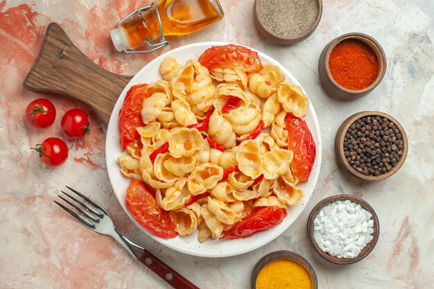 Sopra vista gustose conchiglie su un piatto bianco su tagliere di legno