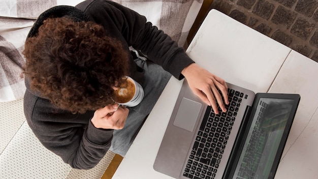 Sopra vista ragazzo che lavora al computer portatile