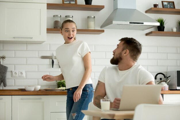 Sorpreso moglie entusiasta di ascoltare le notizie dal marito in cucina