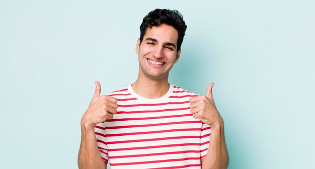 sorridendo ampiamente guardando felice positivo fiducioso e di successo con entrambi i pollici