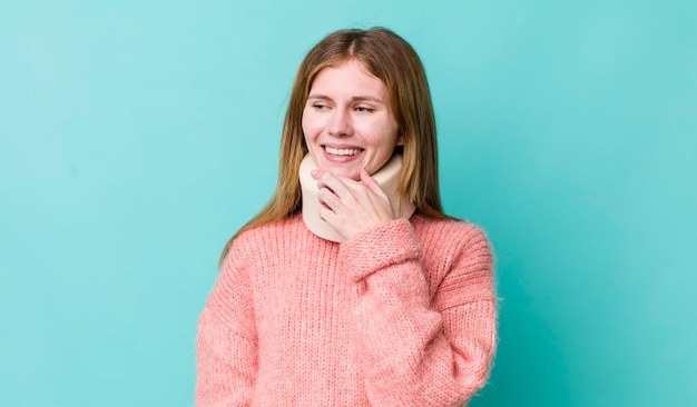 Sorridendo con un'espressione felice e sicura con la mano sul mento