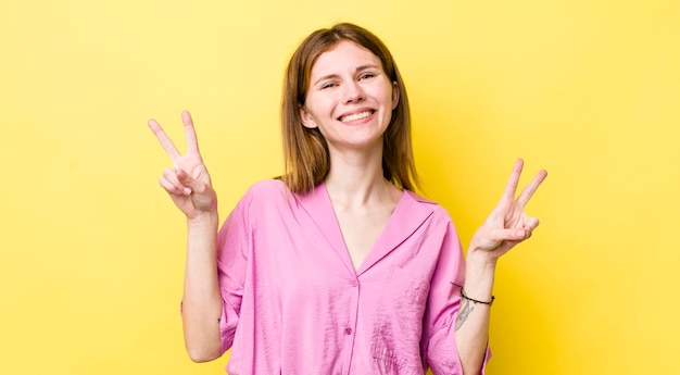 Sorridendo e guardando felice, amichevole e soddisfatto, gesticolando vittoria o pace con entrambe le mani