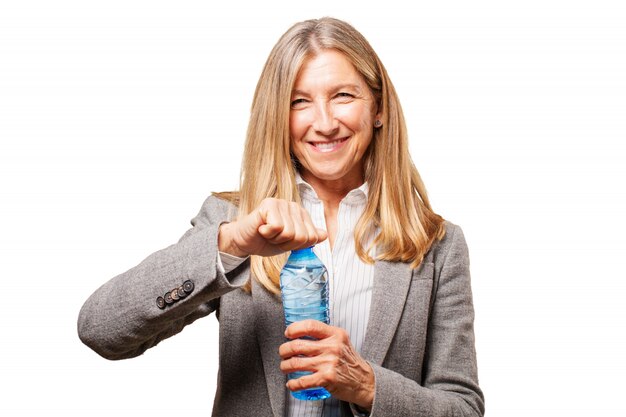 Sorridente anziano donna, aprendo una bottiglia d&#39;acqua