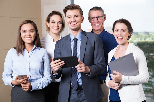 Sorridente Business team in piedi in sala conferenze