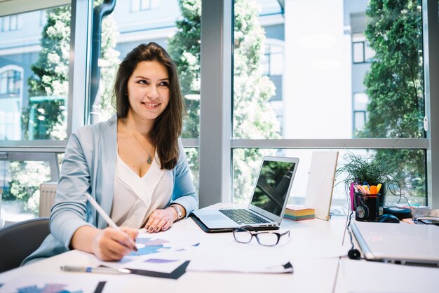 Sorridente donna sognante con documenti