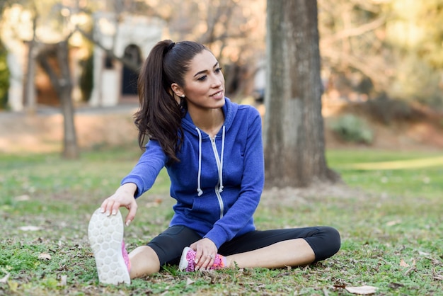 Sorridente donna stretching prima di correre