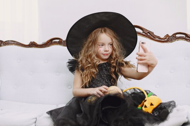 Sorridente felice bambina strega positiva in costume di halloween di carnevale