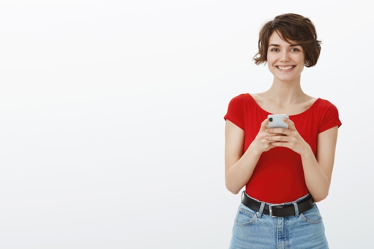 Foto gratuito sorridente giovane donna attraente texting sul cellulare, utilizzando l'app di incontri sullo smartphone