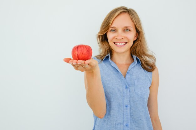 Sorridente giovane donna bella tenendo mela rossa