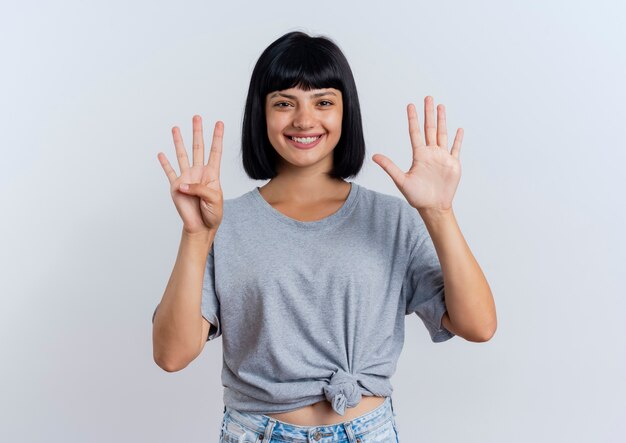 Sorridente giovane donna caucasica bruna gesti quattro con le dita