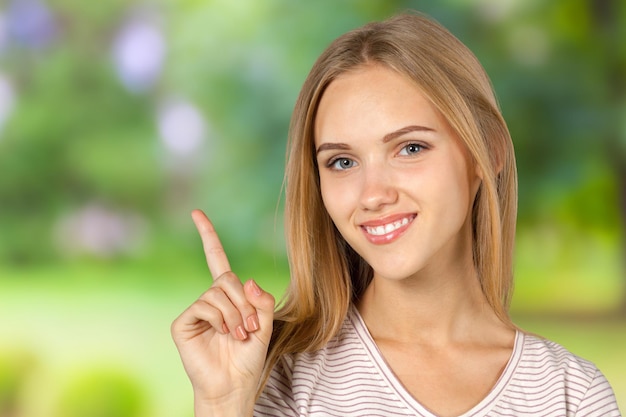 Sorridente giovane donna che indica