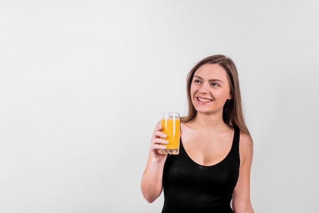 Sorridente giovane donna con un bicchiere di succo
