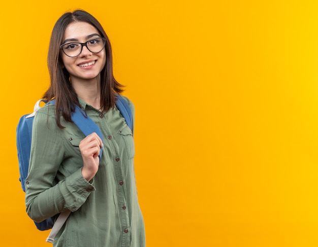 Sorridente giovane donna della scuola che indossa uno zaino con gli occhiali