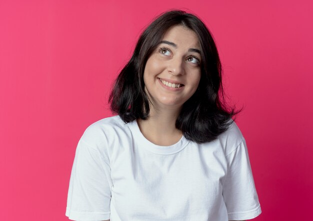 sorridente giovane donna piuttosto caucasica guardando lato isolato su cremisi