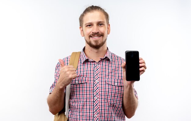 Sorridente giovane studente che indossa lo zaino che tiene e indica il telefono