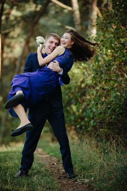 Sorridente groomsman che trasporta la damigella d&#39;onore ridente