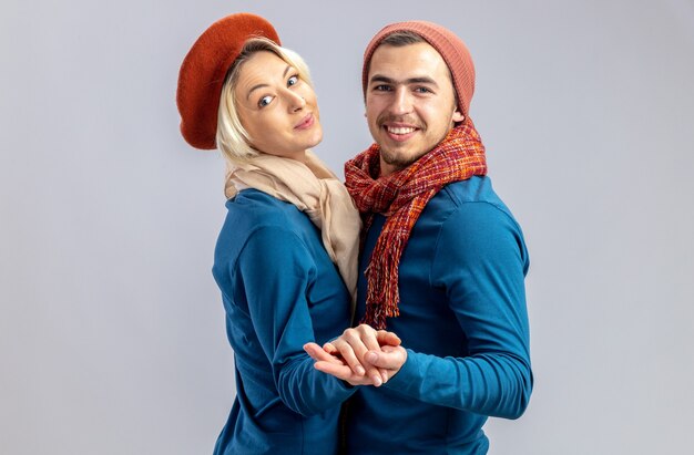 Sorridente guardando fotocamera giovane coppia il giorno di san valentino indossando cappello con sciarpa danza isolato su sfondo bianco