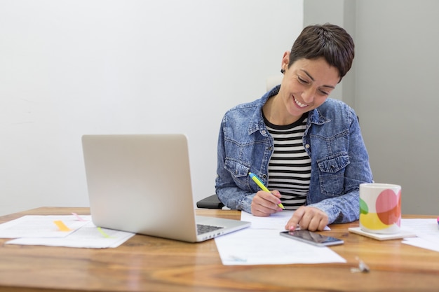 Sorridente imprenditrice di firmare un documento