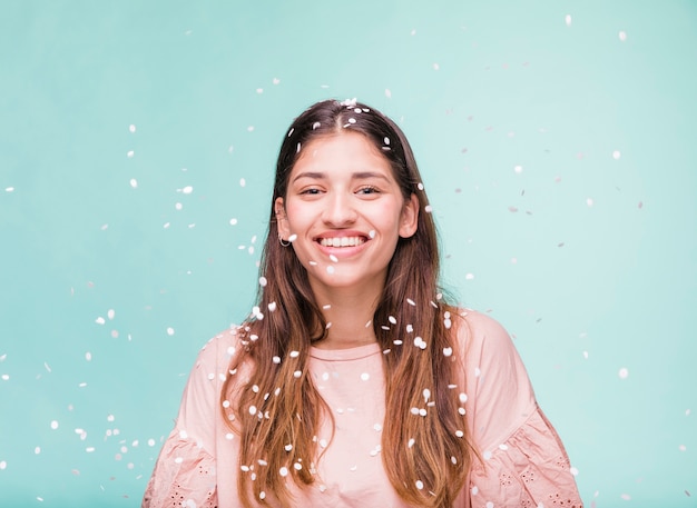 Sorridente ragazza bruna con coriandoli