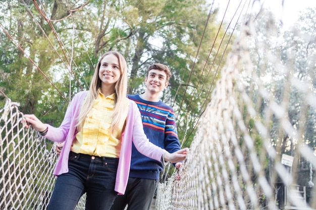 Sorridente ragazza di attraversare il ponte con la sua amica