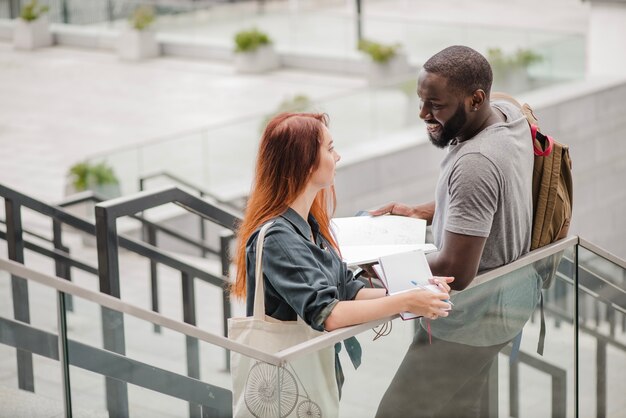 Sorridente uomo e donna con docs sulle scale