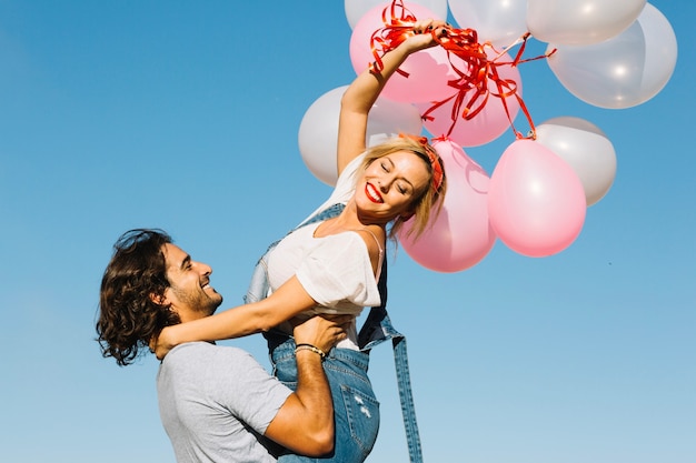 Sorridente uomo e donna con palloncini