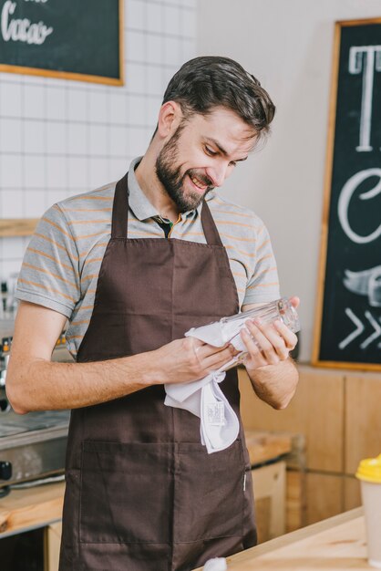 Sorridente uomo pulizia del vetro