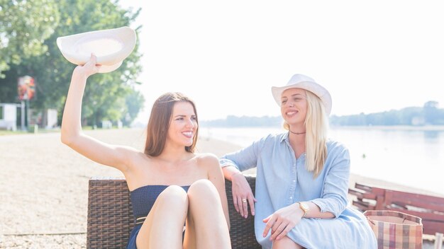 Sorridenti amici femminili godendo in spiaggia